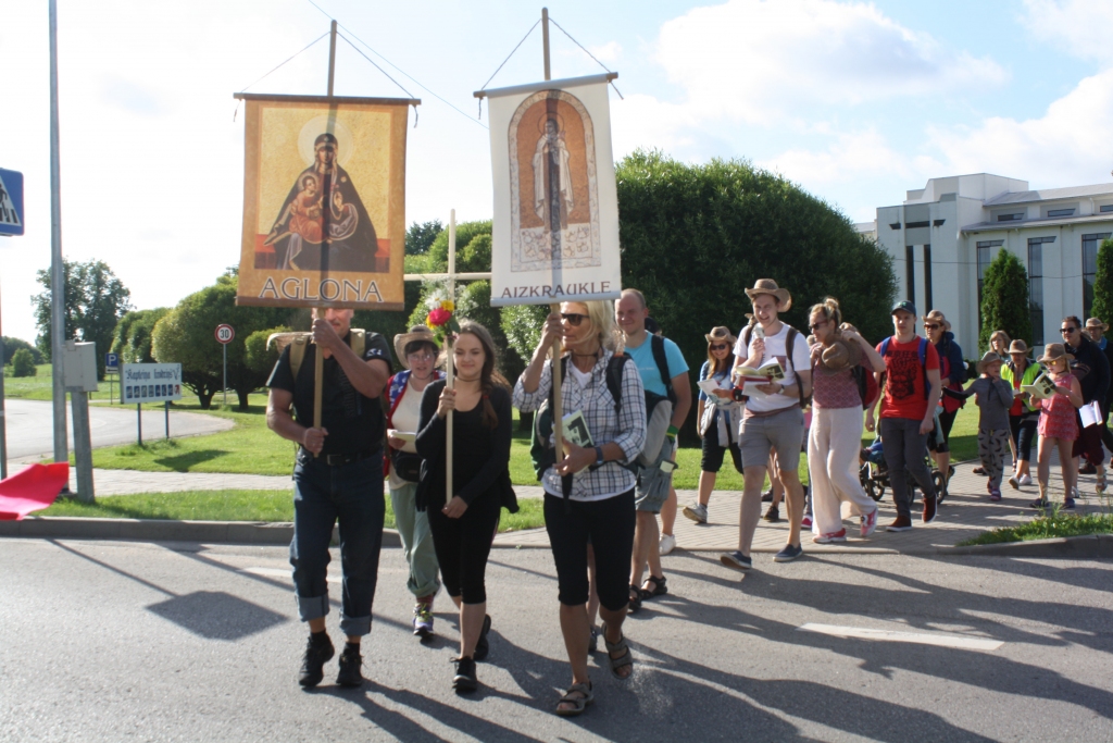 DODAS CEĻĀ. Aizkraukles Svētās Terēzes no Bērna Jēzus Romas katoļu draudzes svētceļnieku grupa dodas ceļā uz Aglonu. Svētbildes attēlu ar uzrakstu “Aglona” nes draudzes pārstāvis Harijs Lonskis, krustu — Katrīna Lūse no Siguldas, svētbildes attēlu ar uzrakstu “Aizkraukle” — Silvija Ozoliņa no Aizkraukles draudzes.