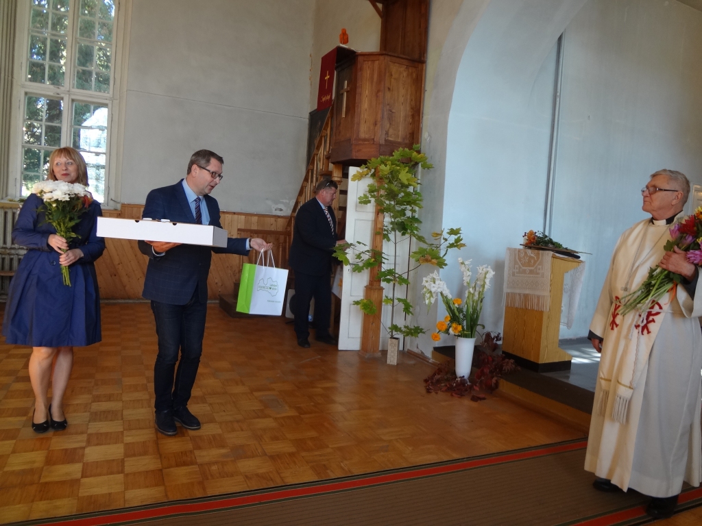 APSVEICĒJI. Novada domes priekšsēdētājs Dainis Vingris un sabiedrisko attiecību speciāliste Sarmīte Rode sveic mācītāju Valdi Baltruku dievnama jubilejā.
Autors: Mārcis Briška