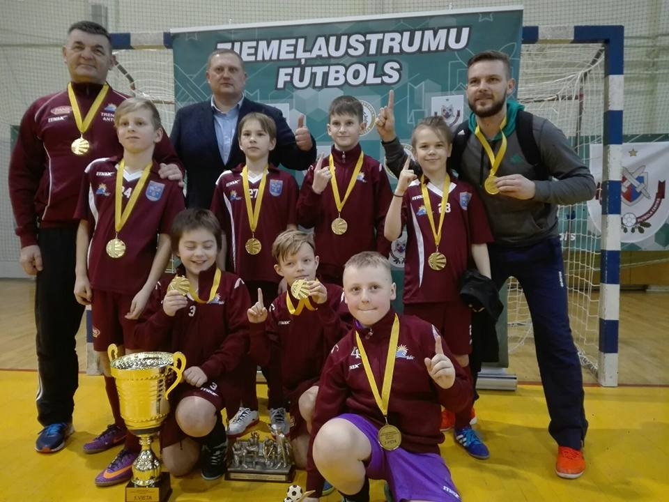 LATVIJAS ČEMPIONI, saņemot uzvarētāju kausu U 10 vecumgrupā. Aizkraukles futbola kluba “Veina” mazie futbolisti kopā ar treneriem Antonu (no kreisās) un Gati Ciematniekiem.
Autors: no kluba arhīva