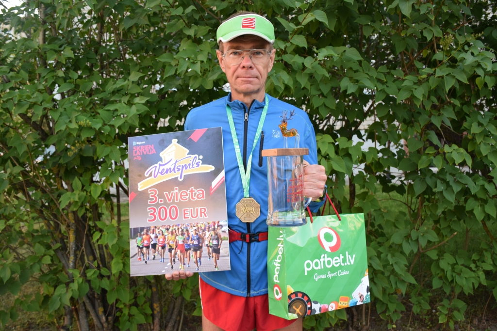 IEGŪST ARĪ NAUDAS BALVU. Normunds Laucis priecājas ne tikai par pirmo vietu maratonā savā vecuma grupā un trešo vietu kopvērtējumā, bet arī par 300 eiro naudas balvu, dāvanu karti 40 eiro vērtībā, brieža statueti un stikla kausu, kas apbalvošanas ceremonijā bija pilns ar zemenēm, un citām dāvanām. Šogad Normunds Laucis noskrējis jau divus maratonus, piecus pusmaratonus un visos izcīnījis godalgotu vietu. Tagad viņš gatavojas pasaules čempionātam 100 km skrējienā, kas septembrī notiks Horvātijā.