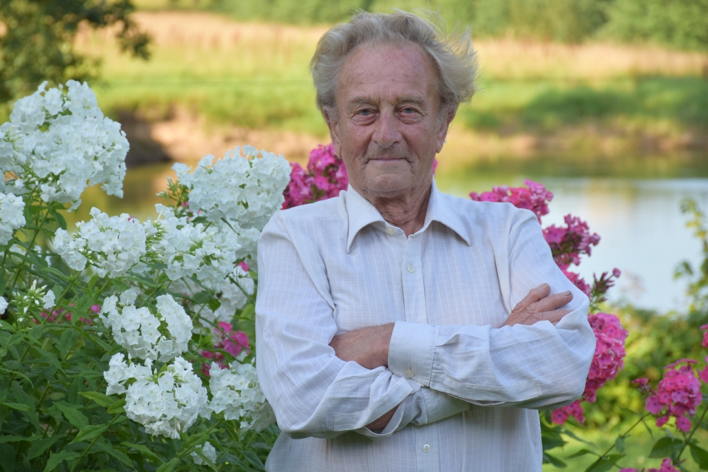 KAZIMIRS ŽOGOTS par savu flokšu dobi saka: “Mans sārti baltais karogs”. Pie tā arī top jubilāra bilde.