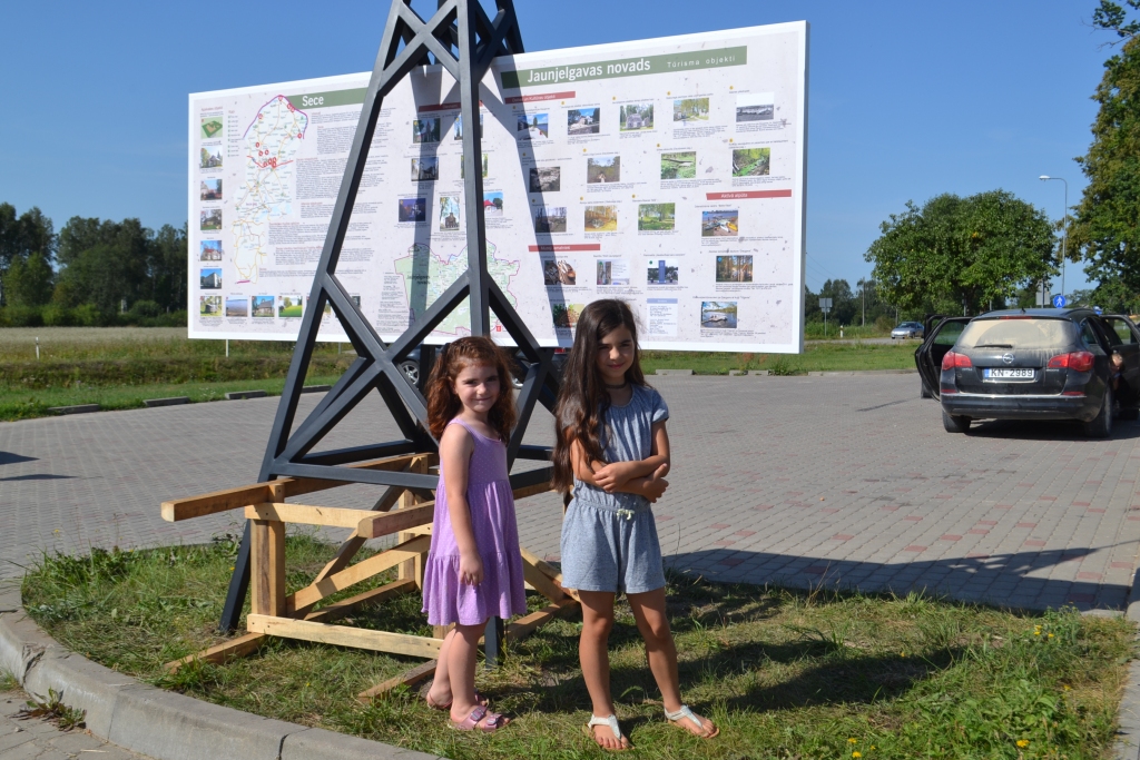 INFORMĀCIJAS STENDS Seces pagasta centrā veidots kā stilizēts Strūves ģeodēziskā loka observatorijas tornis, kāds savulaik bijis arī Secē. Jaunais objekts piesaista garāmgājējus, arī māsas Sofiju un Eleonoru.