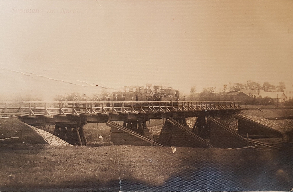 Tilts pār Susēju Neretā. Satiksmē tas nebija lietojams, bet gājēji pār to varēja pāriet. Lūcija Ķuzāne atceras, ka “iešana pāri bija briesmīgi bailīga, jo kājas bija jātrāpa uz tādām kā redelēm, un, lejā veroties, varēja redzēt upi. Reizēs, kad ģimene no Pilskalnes puses brauca uz Neretas tirgu, tēvs pajūgu laida apkārt pa sudmalu tiltu, bet es ar māti, lai ātrāk paspētu nopirkt sviestu, ceļu īsinot, izmantojām dzelzceļa tiltu”.
Autors: no neretietes Ārijas Zālītes albuma
