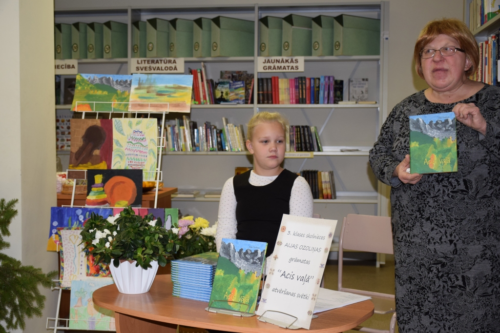 Grāmatiņas “Acis vaļā” dzejoļu autore Aija Ozoliņa (no kreisās) kopā ar krājuma veidotāju, skolotāju un grāmatu autori Lidiju Ozoliņu Aijas grāmatas atvēršanas svētkos Aizkraukles bērnu bibliotēkā.