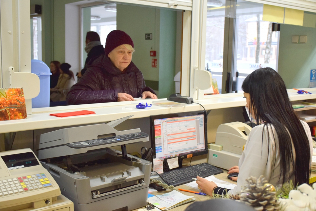 GAIDA, KAD SĀKS DARBOTIES JAUNĀ SISTĒMA. Attēlā — aizkrauklieti Aldas kundzi Aizkraukles poliklīnikas reģistratūras darbiniece Marina Derijeva apkalpo tāpat kā iepriekš — 2018. gadā.
Autors: Imants Kaziļuns