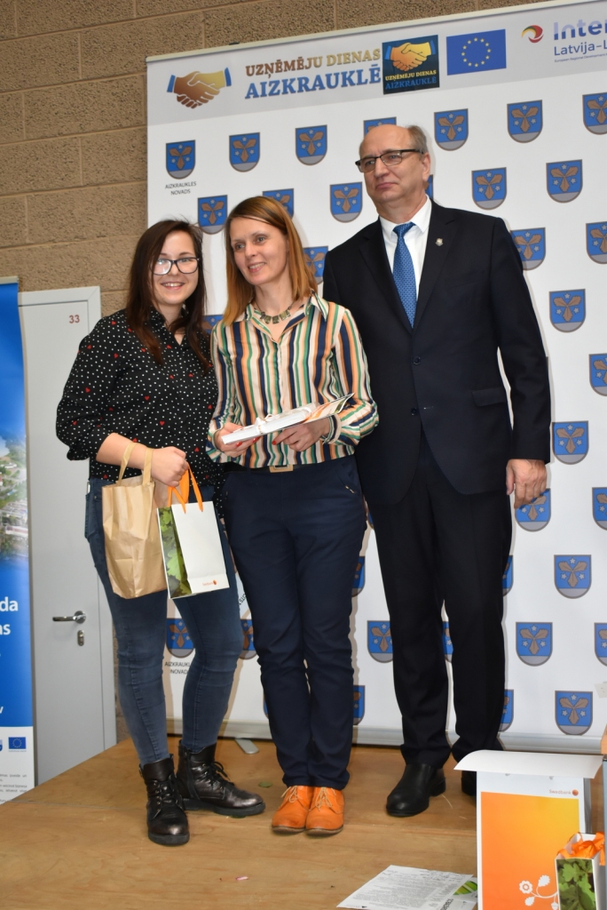 Nominācijas “Labākā dāvana” ieguvēja. Aizkraukles skolēnu mācību uzņēmuma “Kā mājās” pārstāve Veronika Kareva (no kreisās) ar skolotāju Zani Sirmaci-Liedskalniņu un domes priekšsēdētāju Leonu Līdumu.