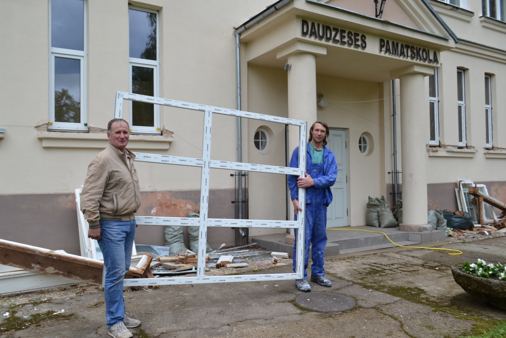 Labi iederas. Daudzeses pamatskolas direktors Valdis Puida (no kreisās) un uzņēmuma “Mūsu lodzinieks” strādnieks Modris Everts atzīst, ka jaunie logi labi iederas vecās skolas fasādē.
