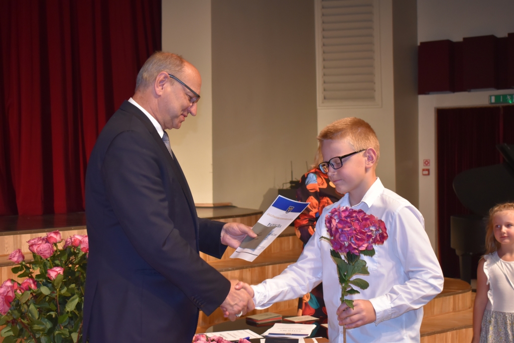 Aizkraukles novada domes priekšsēdētājs Leons Līdums pasniedz balvu Aizkraukles Mūzikas skolas audzēknim Robertam Lukevičam (pedagoģe Natālija Juškeviča) par iegūto 2. vietu starptautiskajā akordeonistu solistu konkursā “Naujene 2019” .
