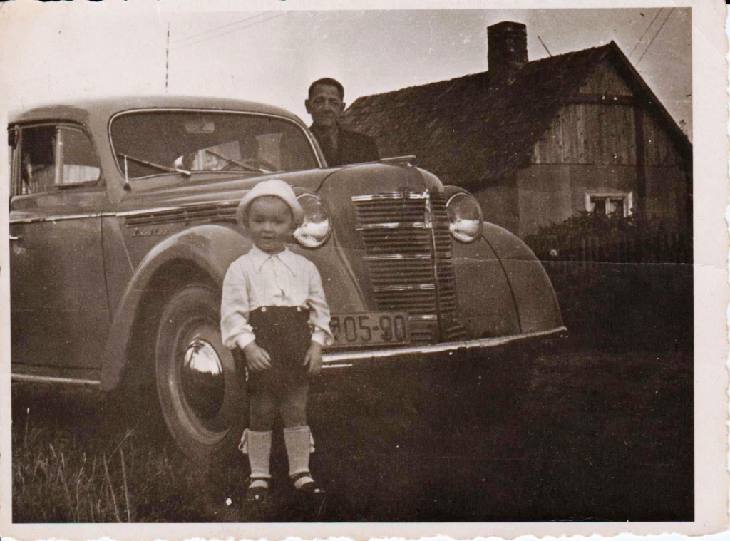Pāri auto lūkojas mans vectēvs Osvalds Skoderis, priekšplānā es, Jānis Kalējs.