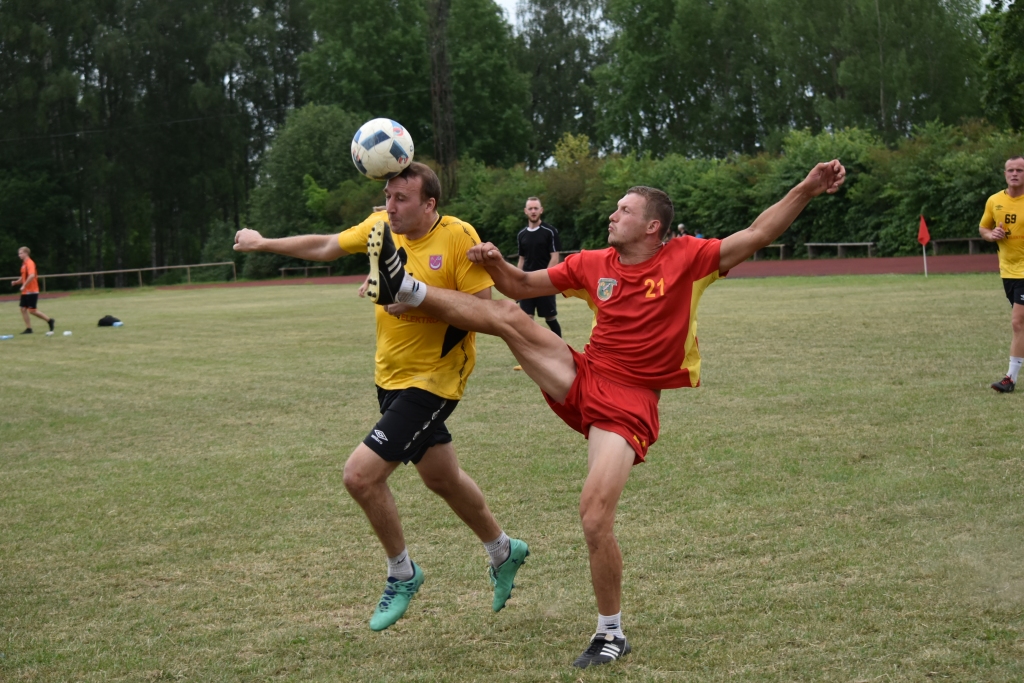 Viens spēlē ar galvu, cits ar kājām. Spēles moments mačā starp vienības “Poila” un “Skrīveri” futbolistiem.