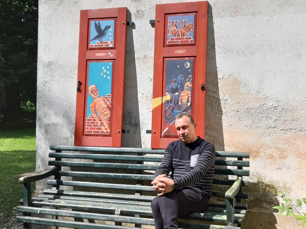 Arūns Augutis, Lietuvas mākslinieks, pirms 15 gadiem aizsāka īstenot ideju par apgleznotiem logu slēģiem Rokišķos. Nu šī ideja turpinājumu radusi Latvijā, un viņš savā darbā attēlojis stāstu par Zasas barona mūmiju.