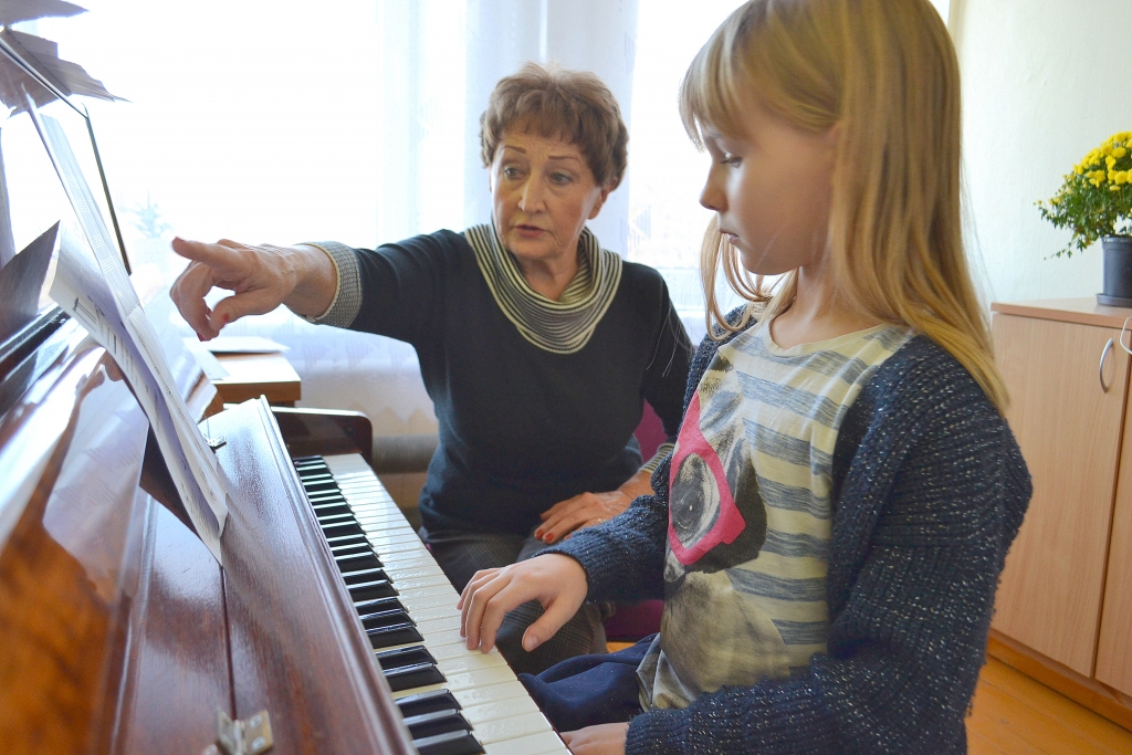 Ar skolnieci Olīviju. Skolotāja Olga Siliņa jau vairāk nekā četrdesmit gadu nenogurstoši māca klavierspēli.