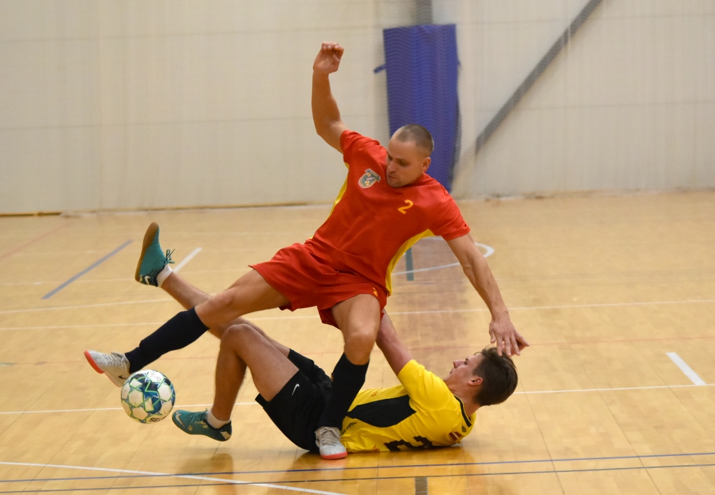 Klupdami krizdami — tik uz priekšu! Komandas “Poila” futbolists Aivis Laiviņš (zemē), esot horizontāli, nerimstas cīnīties par bumbu, kuru nolūkojis arī skrīverietis Ainārs Mičulis.