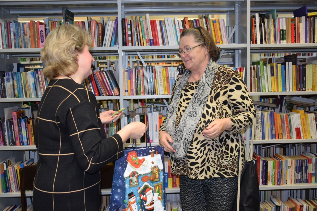 Prieks un pateicība aktīvajiem lasītājiem. Aizkraukles pilsētas bibliotēkas bibliotekāre, erudīcijas konkursa ierosinātāja Inese Rubule pasniedz balvu lasītājai Zigrīdai Zaņevskai.