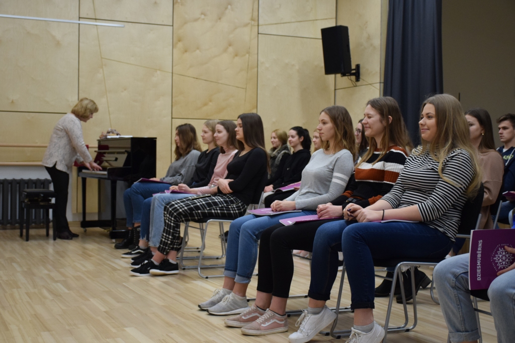 Skan labi! Gaišajā un mājīgajā, vēl pēc svaiga koka smaržojošajā Kokneses vidusskolas sarīkojumu zālē divas reizes nedēļā agri rītā uz mēģinājumu pulcējas vidusskolas jauktais koris Initas Asarītes vadībā. Šobrīd jaunieši gatavojas Skolu jaunatnes dziesmu un deju svētkiem.