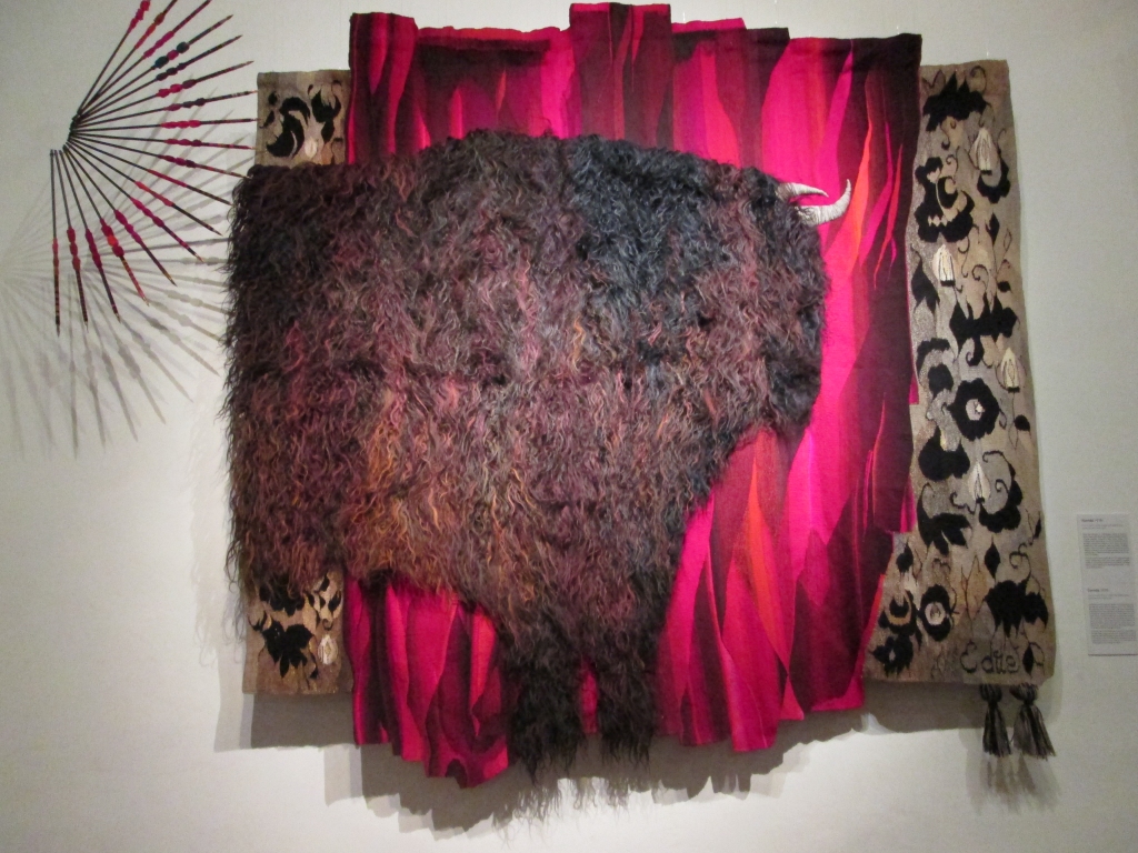 Korrida. ““Korridā” centrālo vietu ierādīju vērsim. No Karpatiem  draugi atsūtīja garšķiedraino aitas vilnu, tēvs palīdzēja izgatavot muletes, kuras izkārtoju vēdekļa formā. Dekoratīvi — sarkanajā fonā  un auduma fragmentos kompozīcijas abās pusēs — ir kaut  kas no matadora tērpa.” (No anotācijas.)