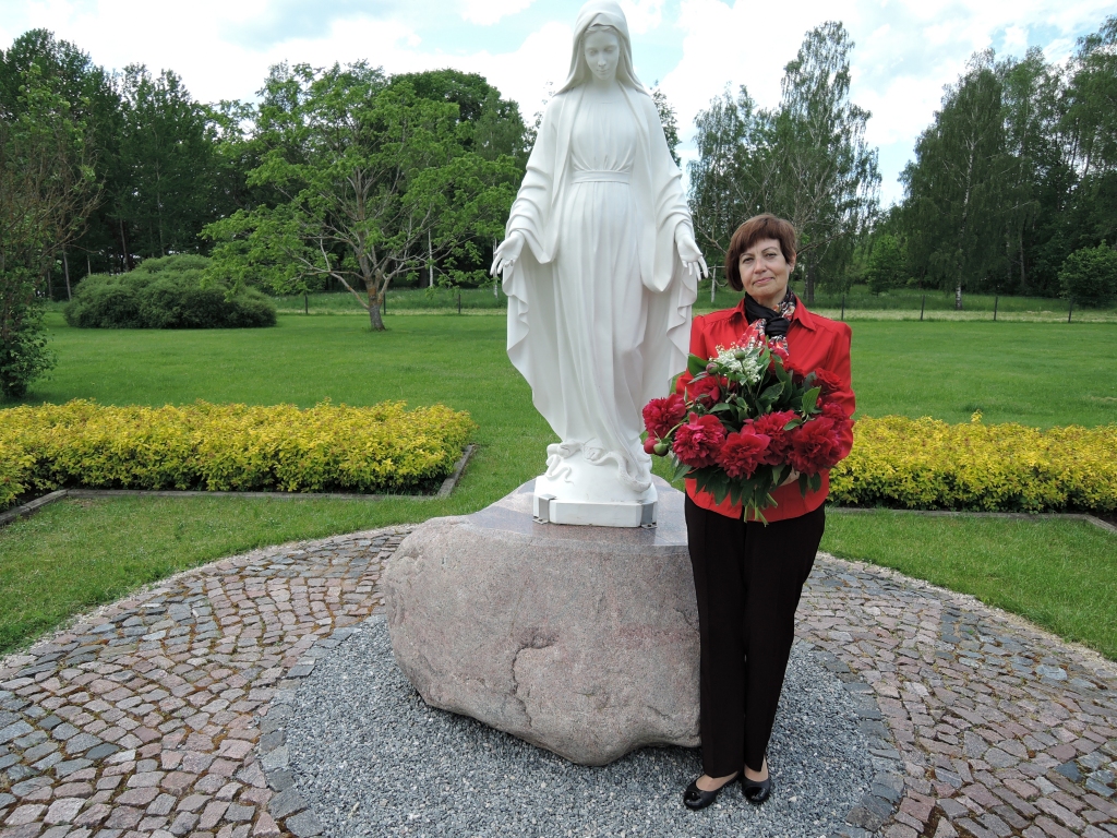 SVĒTKOS. Svētās Terēzes no Bērna Jēzus Aizkraukles katoļu baznīcas pagalmā pie Svētās dievmātes statujas, kas Sandrai Krūmiņai ir ļoti mīļa vieta. Draudzes koristi zina, ka viņas mīļākās puķes ir peonijas un maijpuķītes, tādēļ jubilejas reizē dāvināja tieši tās.
Autors: no personiskā arhīva