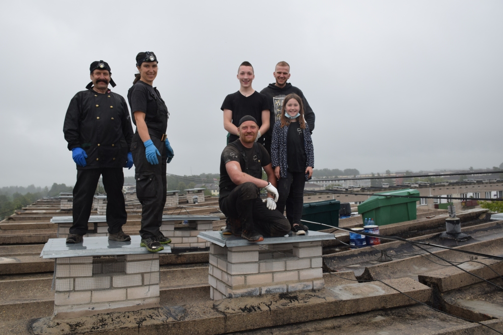 Heijā, Aizkraukle! Uz Gaismas ielas 8. mājas plakanā jumta ventilācijas tīrītāju brigāde — Līga Ondzule ar tēvu Jāni Andersonu (no kreisās), viņu draugi no Talsiem — Elijs Bite ar bērniem un mācekli Gati Čiekuru (aizmugurē no labās). Talsu draugi, kuri pēc savas iniciatīvas palīdzēja pirmajās divās dienās, aizbraukuši, un nu darbs tiek turpināts divatā.