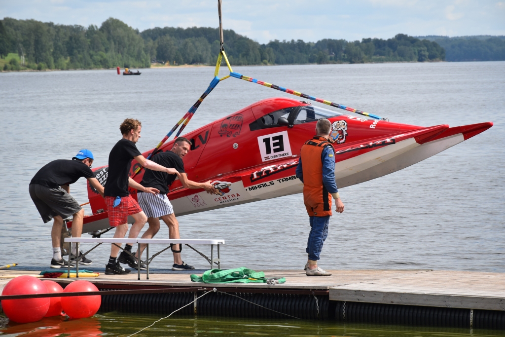 KOMANDAS DARBS. Aizkraukles novada svētku apmeklētājiem bija iespēja vērot ātrumlaivu sacensības — Latvijas atklātā čempionāta ūdens motosportā trešajā posmā piedalījās visu triju Baltijas valstu 48 piloti dažādās klasēs. Atbilstoši laivu klasei smagākās laivas, kas sver pat 350 kilogramus, ūdenī iecēla ar ceļamkrānu, bet vieglākās pa pontonu laipu piekabē tika aizstumtas līdz sacensību vietai un tad ar rokām ieceltas ūdenī. Pilota uzdevums ir braukt, bet par laivu gādā zinoša un fiziski spēcīga tehniskā atbalsta komanda. Katra spīdoša uzvara ir ne tikai sportista, bet visas komandas saliedēts darbs.