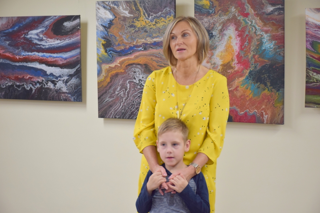 Ilva Ievāne kopā ar mazdēlu Rodrigo izstādes atklāšanā.