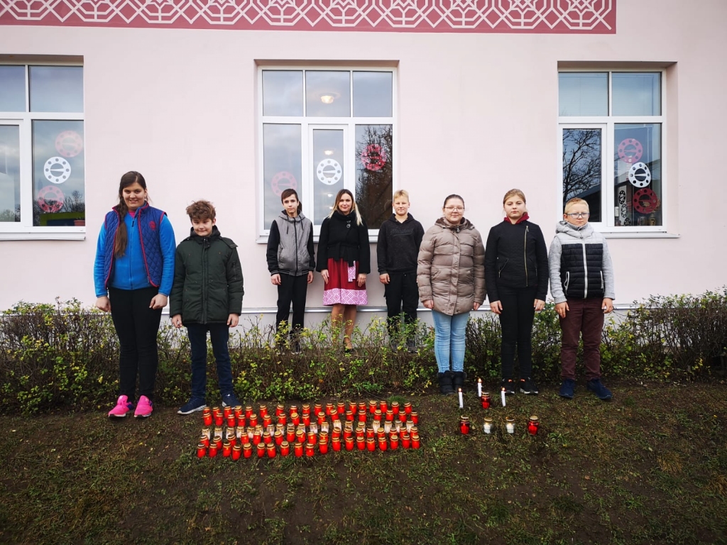 Pērses sākumskolas 6. klases audzēkņi kopā ar skolotāju, skolas vadītāju Santu Kalniņu (vidū) Lāčplēša dienā pie savas skolas.
Autors: no Pērses sākumskolas