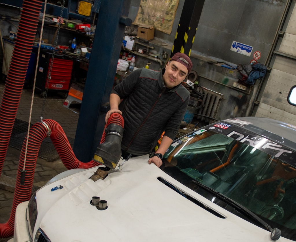 TURPMĀK BEZ KODĪGIEM DŪMIEM TELPĀ. Kristaps Kāpiņš uz sava sacīkšu auto rāda jauno atgāzu nosūkšanas sistēmas darbību.