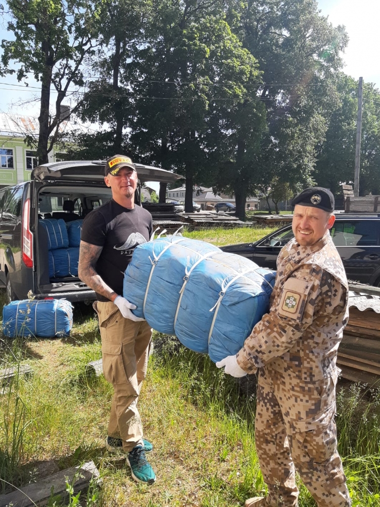 APĢĒRBS NO VĀCIJAS. Zemessardzes 55. kājnieku bataljona civilmilitārās sadarbības speciālists Inguss Ikstens  (no labās) kopā ar brīvprātīgo Mario Bebrišu no Aizkraukles apģērba pakas nogādā Neretas novada sociālajā dienestā. Uz pakas rakstīts, ka tajā ir dažāds  apģērbs — gan vasaras, gan arī ziemas.
Autors: no Ingusa Ikstena albuma