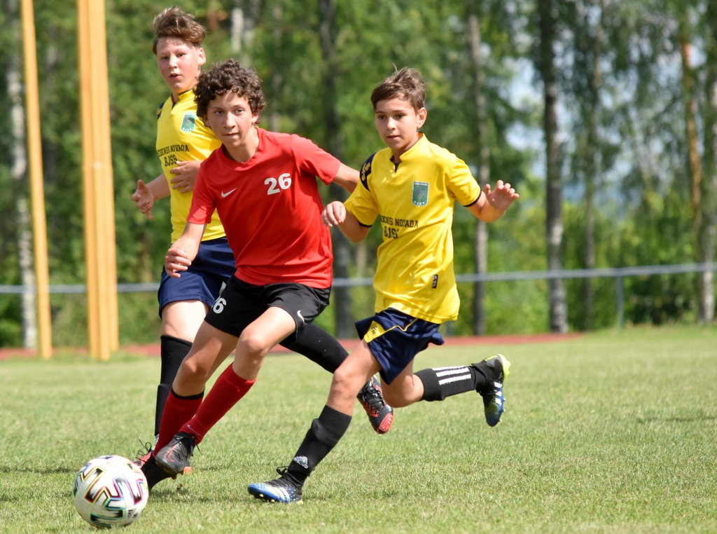 Neapturamie! Vienības “FK Veina” spēlētājs Haralds Poz­ņiaks (vidū) pretinieku ielenkumā turpina realizēt uzbrukumu.