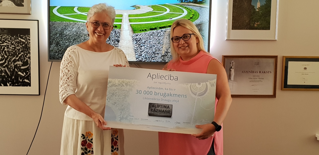 SVINĪGS BRĪDIS. “Jubilejas bruģakmens”  īpašnieci Aļiftinu Rāzmani (no labās) sveic  “Kokneses fonda” padomes priekšsēdētāja, Eiropas Parlamenta deputāte Sandra Kalniete.
Autors: publicitātes