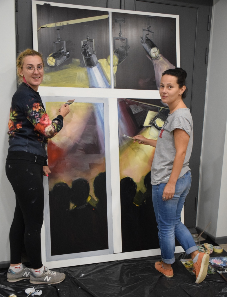 Mākslinieces Ingrīda Suharevska (no kreisās) un Kristīne Guršpone veido gleznojumus Skrīveru centra logiem, kurus varēs apskatīt otrā stāva logu nišās Sporta ielas pusē.