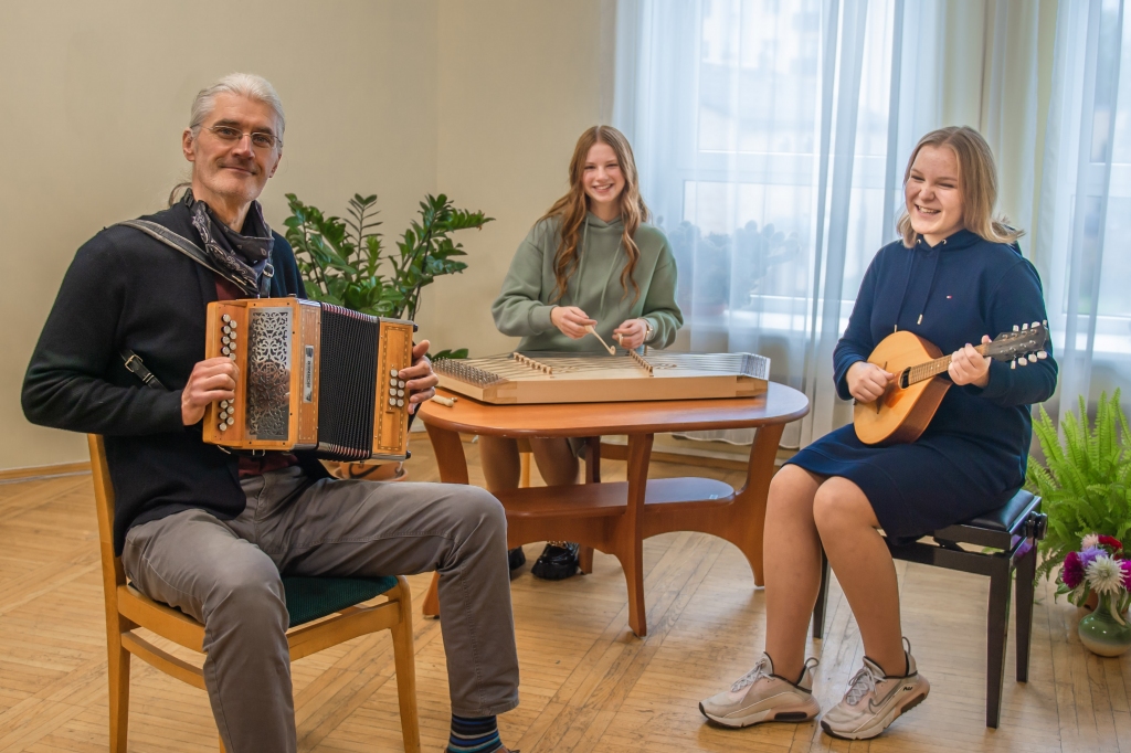 Aizkraukles novada vidusskolas 8. klases audzēknes Paula Laganovska (no labās) ar mandolīnu, Eva Ieviņa ar cimboli un tradicionālo instrumentu ansambļa vadītājs Ilmārs Pumpurs. Meitenes ikdienā apgūst vijoles un klavieru spēli.