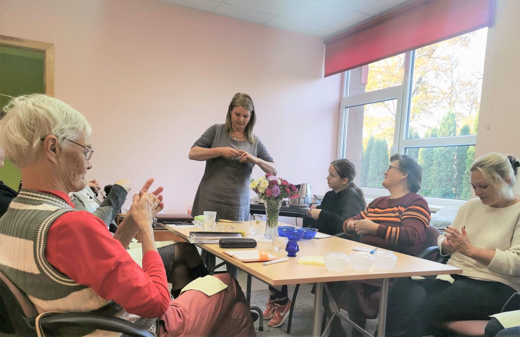 Biedrības “Ērberģietes” sievas vienmēr centušās apgūt ko jaunu, gan iesaistoties dažādos projektos, gan tiekoties reizi mēnesī un uzaicinot ciemos kādu interesantu personību. Oktobra sākumā pie Mazzalves aktīvajām dāmām viesojās zāļu sieva, stāstniece un pirtniece Līga Reitere ar meistarklasi par ārstniecības receptēm mājražošanā, informē biedrības pārstāve Žanna Miezīte. “Saruna izvērtās visai neparasta. Tās laikā nokļuvām rudenīgās dažādu sažāvētu augu smaržās. Kamēr ūdens peldē uzsildītā eļļā ievilkās dažādas zālītes, runājām par to, kas vajadzīgs, lai cilvēks uzturētu sevi formā — labs miegs, svaigs gaiss, smiekli, labs ēdiens. Gatavojām dušas skrubīšus, ārstniecisku augu eļļas skaistumkopšanai, kopā mācījāmies tos labumus pareizi iemasēt sev rokās, skaļi dziedājām un uzkodām pa kādai karotei skuju, kas samaltas un iemaisītas medū,” stāsta Žanna.
Autors: no Žannas Miezītes albuma