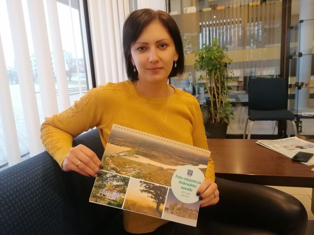 Līga Ciematniece, Aizkraukles novada tūrisma informācijas punkta speciāliste, ar jauno 2022. gada novada kalendāru.