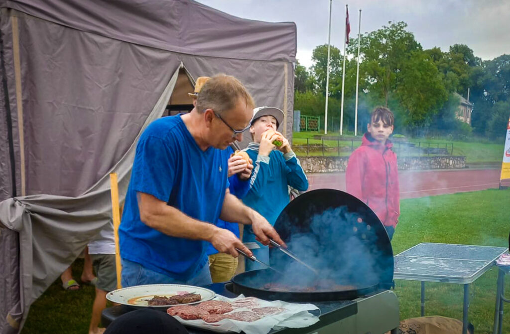 SAVS LAIKS SPORTOŠANAI, SAVS LAIKS ĒŠANAI. Burgeriem gaļu, ar ko cienāja sportistus un līdzjutējus pusdienās un vakarā, bija sagatavojis Uldis Krievārs.